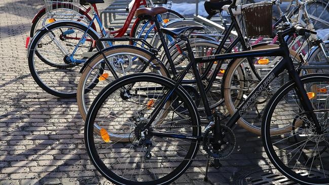 Polkupyöriä pyörätelineessä kävelykadulla