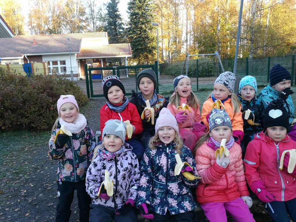 Tuulentuvan päiväkodin lapset syövät banaaneja Reilun kaupan viikon kunniaksi ulkona