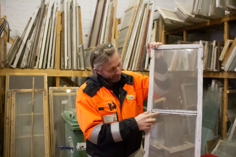 Mies korjaa vanhaa ikkunaa