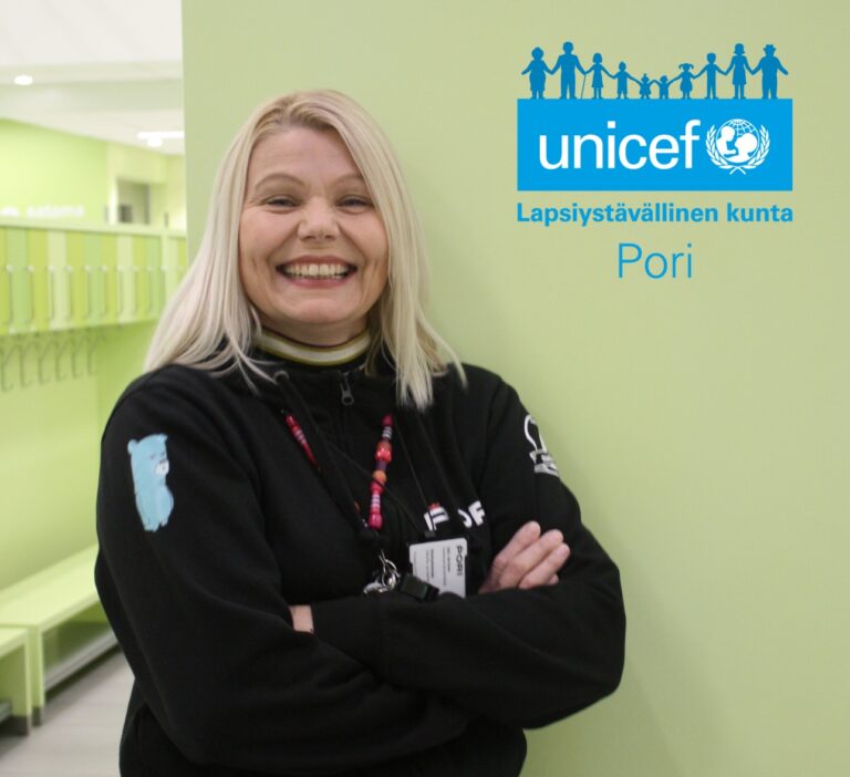 Nainen hymyilee unicef-login vieressä
