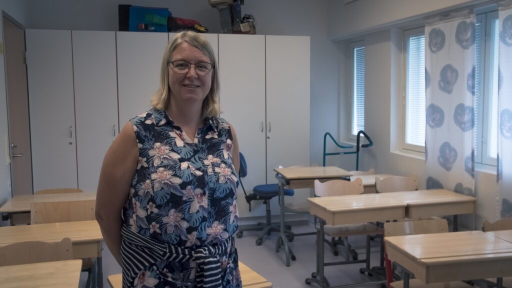 Sari Wallin seisoo luokkahuoneessa
