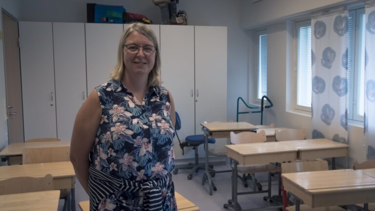 Sari Wallin seisoo luokkahuoneessa