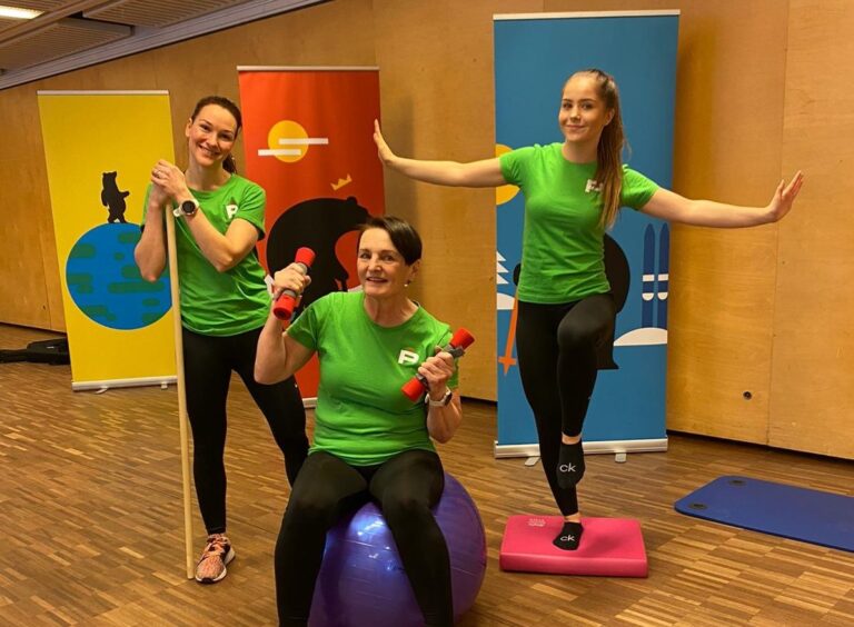 Kolme ihmistä jumppaamassa jumppapallolla ja käsipainoilla.