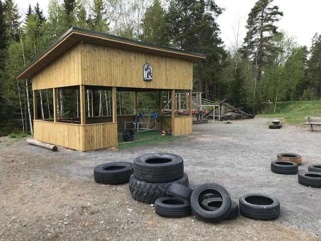 Puinen kuntokatos, jonka edessä kasa traktorin renkaita