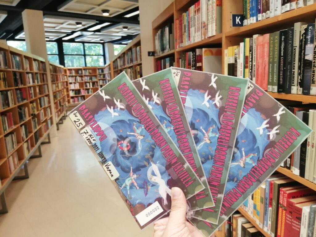 Käsi pitää lippuja Kirjurinluodon Kesäteatterin Koffeli ja Pöffeli -esitykseen