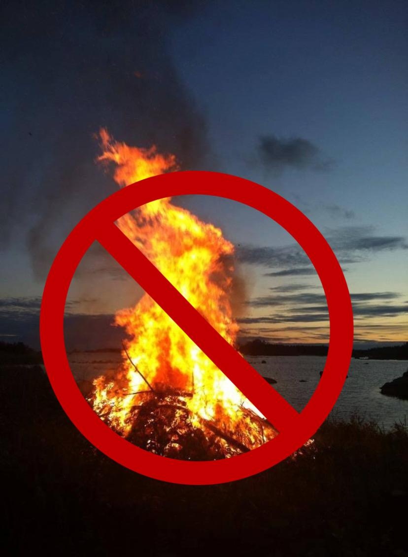 Kuvassa on juhannuskokko, jonka päällä on kieltomerkki.