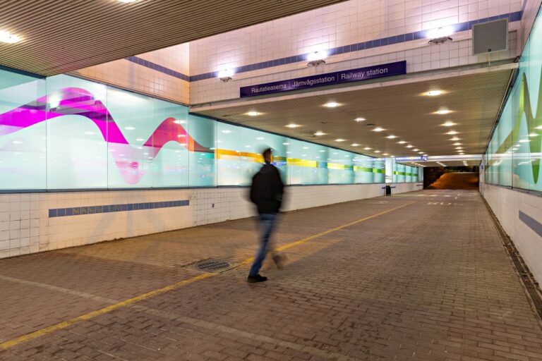 Portaalitunnelin valo- ja ääniteos Porisontti jossa henkilö kävelee kuvan keskellä