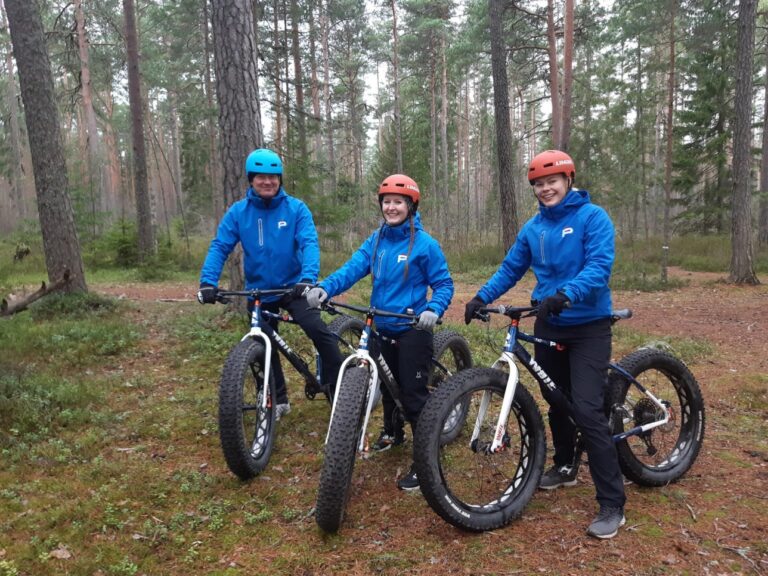 Fatbikellä lenkkeilijöitä metsässä