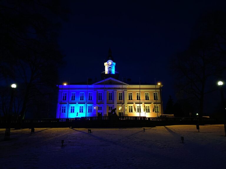 Valokuvassa Porin raatihuone valaistuna sinikeltaiseksi