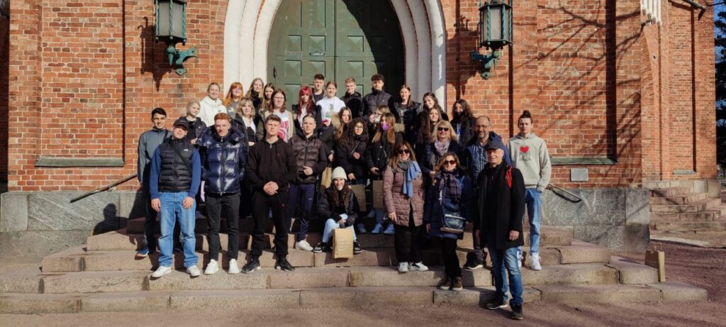 Ryhmäkuva, hankelaiset Keski-Porin kirkon portailla