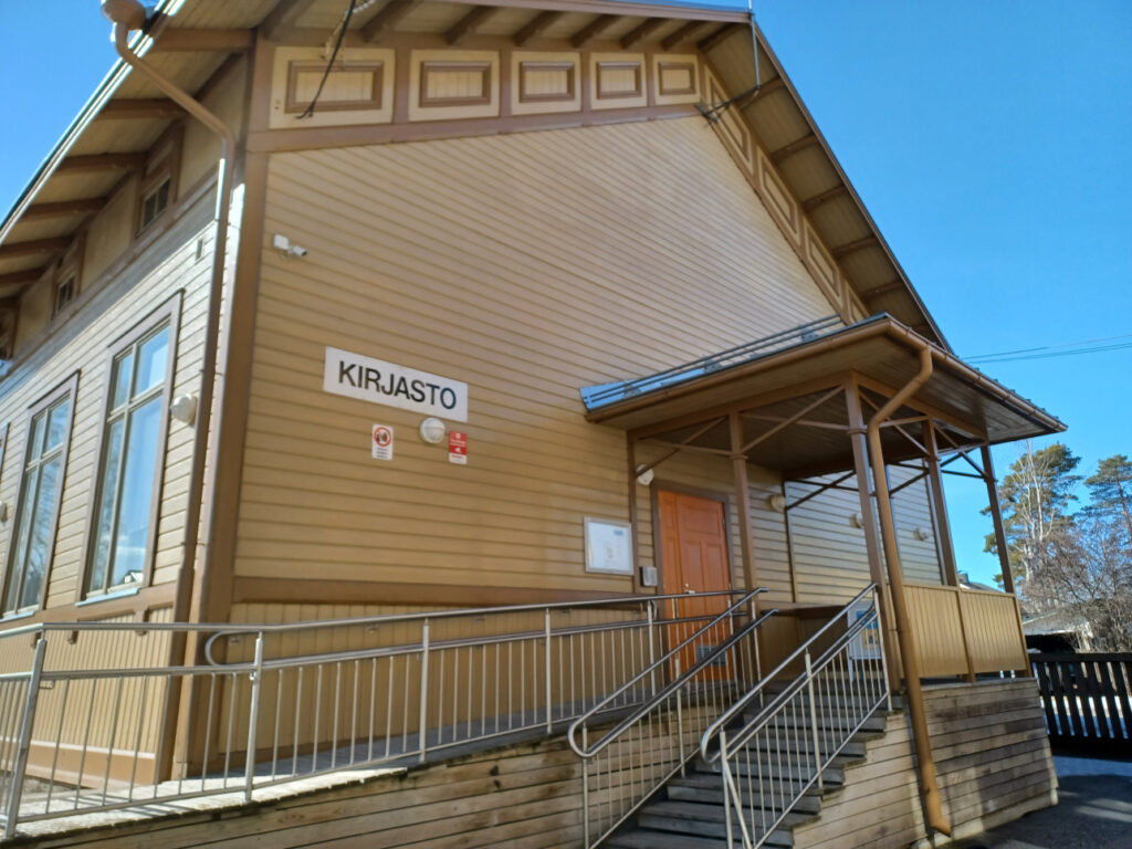 puinen talonseinä jossa on kyltti kirjasto