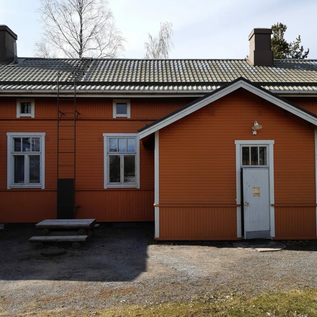 Kuvassa on oranssi puinen talo.