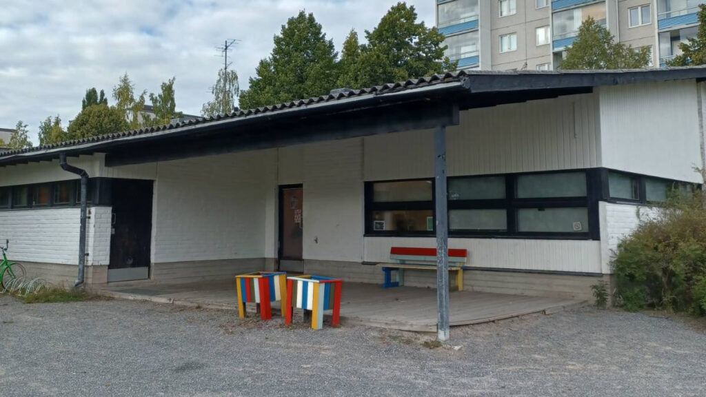 Kuvassa on valkoinen talo, jossa on musta katto.