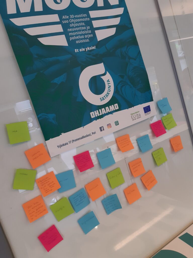 Kuvassa värikkäitä post-it lappuja ja Ohjaamon turkoosi juliste