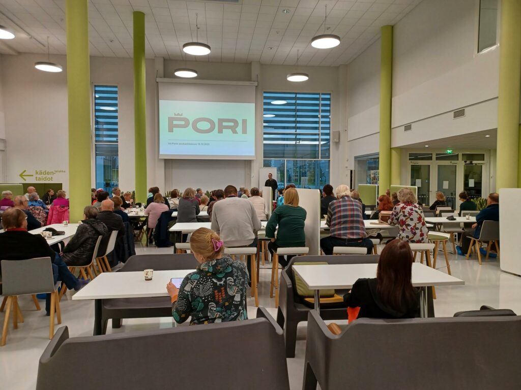 ihmisiä istumassa pöytien ääressä