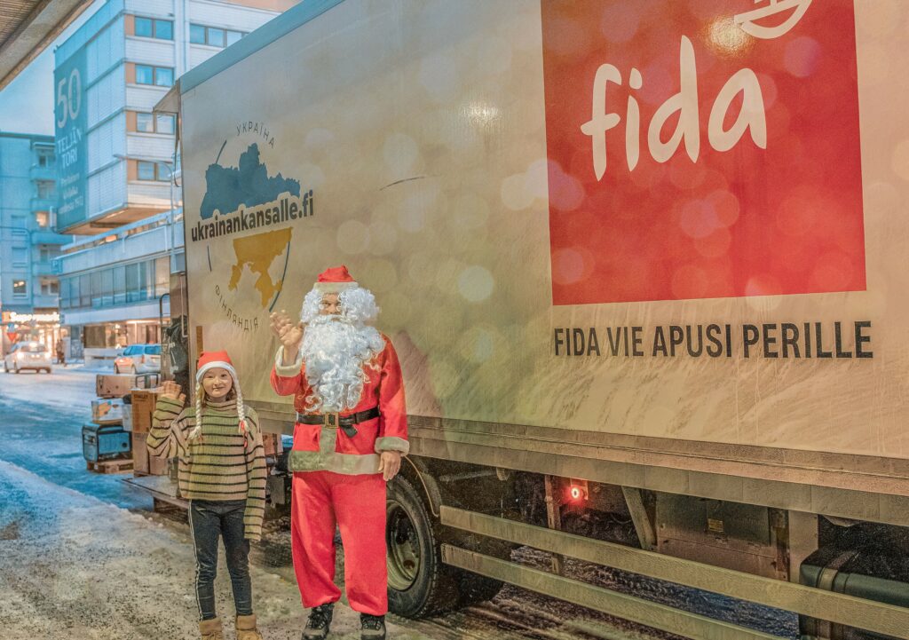 Fidan rekan edessä Joulupukki ja tonttulakkinen lapsi