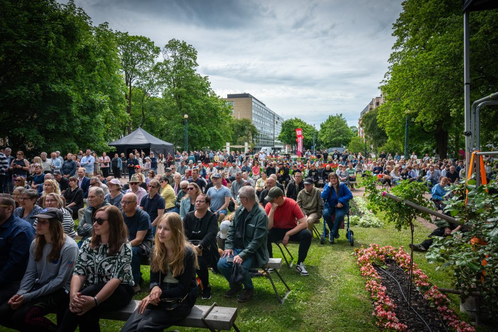 Ihmisiä istumassa penkeillä Raatihuoneenpuistossa