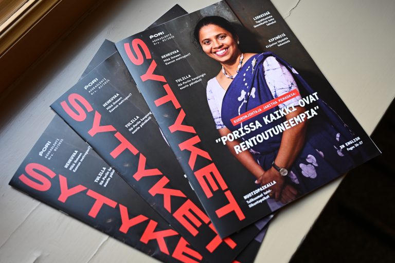 Kolme kaupungin asukaslehteä pinossa. Kannessa hymyilevä nainen värikkäässä puvussa sekä punainen Sytyket-teksti.