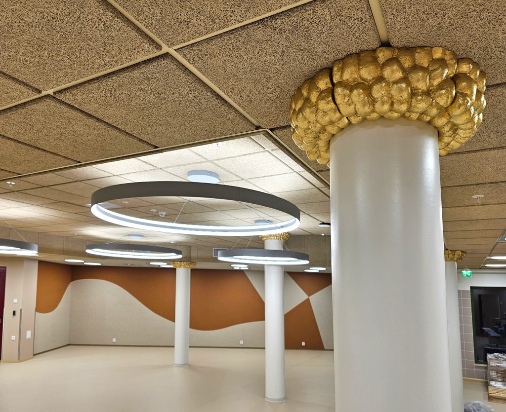 Veijo Setälän kultaiset Leikin varjolla -teokset pilarien yläosissa