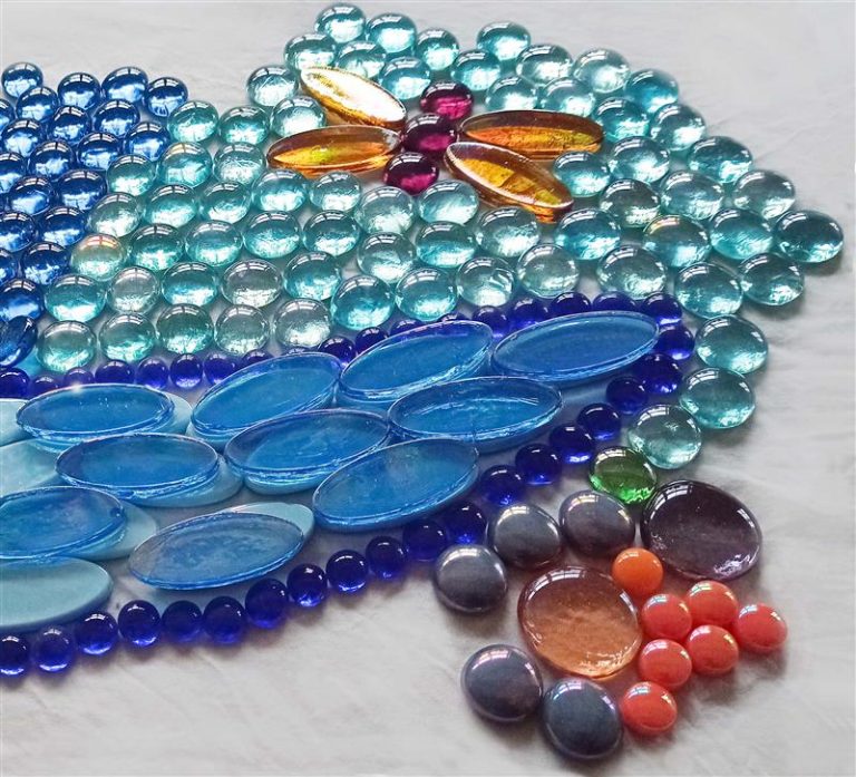 Kuvassa erimallisia ja -muotoisia lasisisa mosaiikkipaloja.