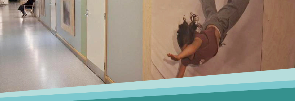 Käytävän seinällä on teos, jossa lapsi hyppää alaspäin.