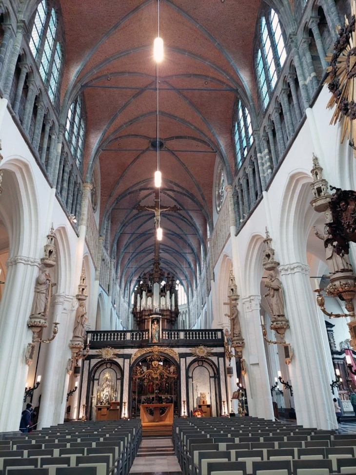 Kuvassa näkyy suuren ja koristeellisen kirkon sisätila, joka edustaa goottilaista arkkitehtuuria.