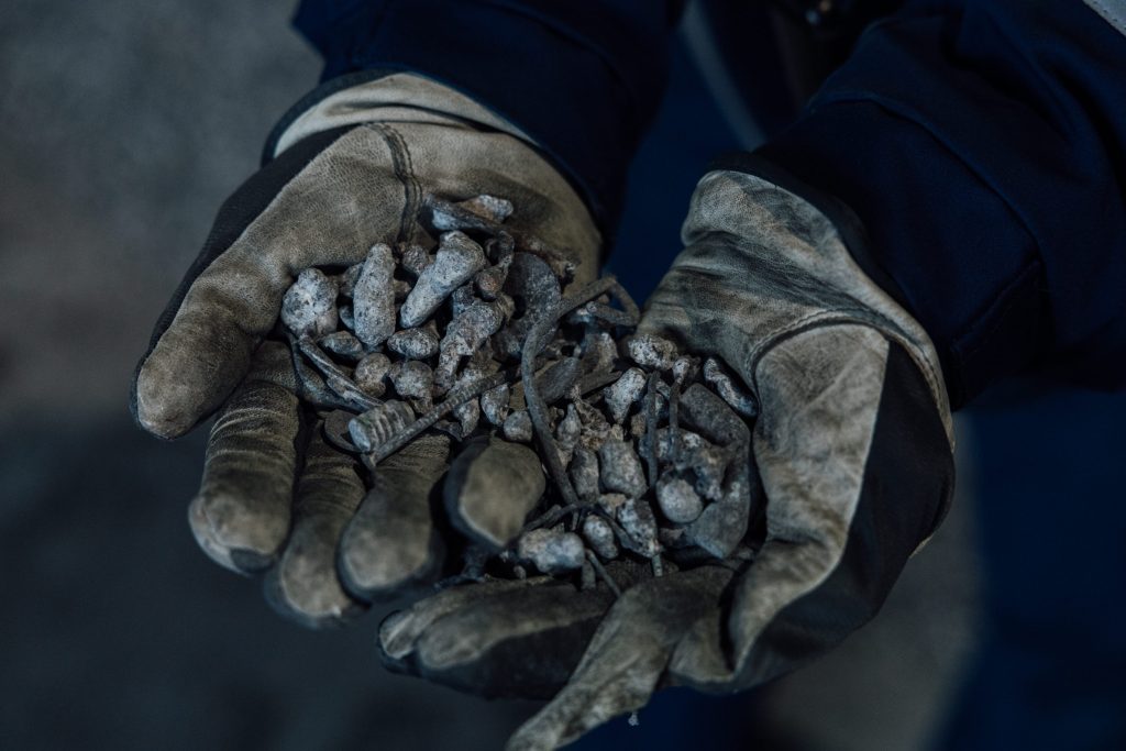 Työhanskat joissa romumetallia ja kuona-aineita