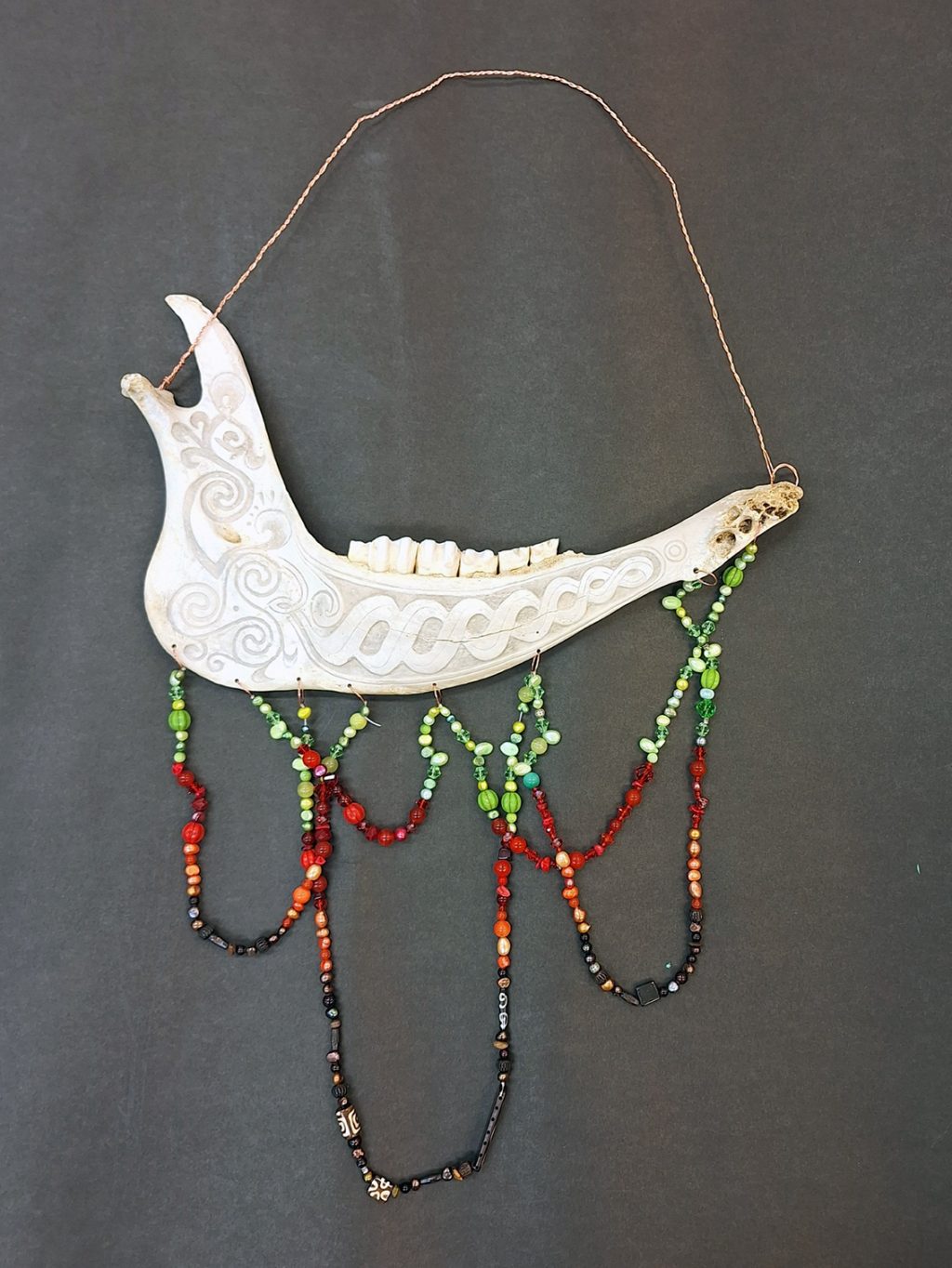 Iiris Arohongan kuvataiteen lukiodiplomityö, joka on eläimen alaleuan luusta käsintehty korumainen taide-esine. Luuhun on kaiverrettu koristeellisia, kiertäviä kuvioita. Leukaluun alareunasta roikkuu useita värikkäistä helmistä tehtyjä nauhoja.
