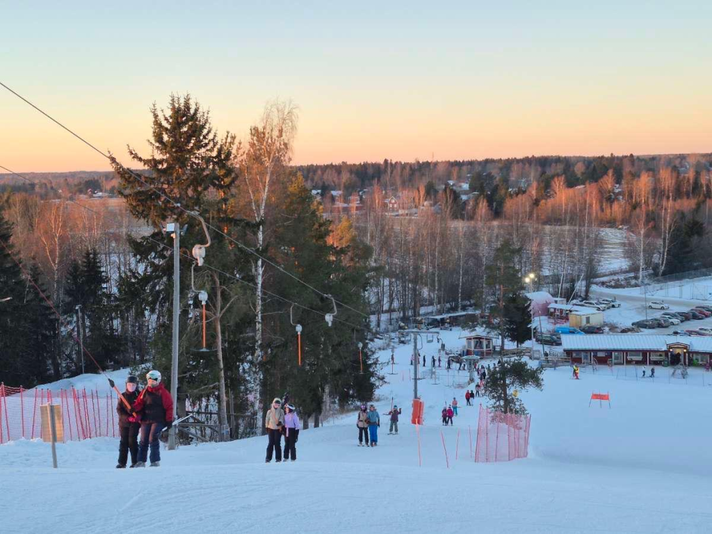 Laskettelijoita nousemassa hiihtohissillä rinnettä ylös