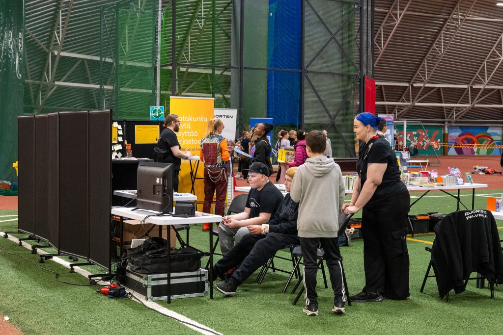 Nuoria pelaamassa pleikkarilla tekonurmihallissa