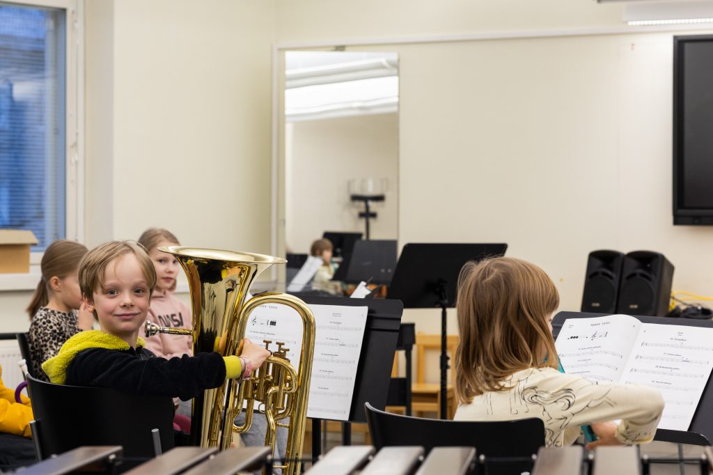 Lapsia soittamassa soittimia luokassa