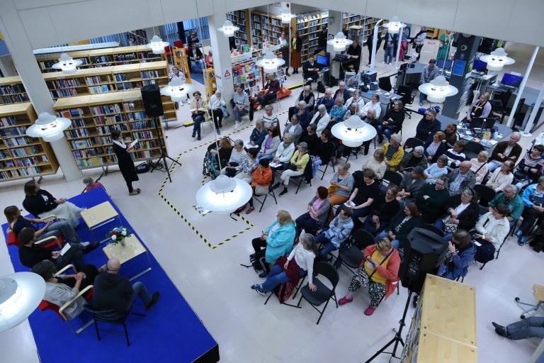 Ihmisjoukko kuuntelemassa pinellä lavalla olevaa tilaisuutta Porin kirjastossa