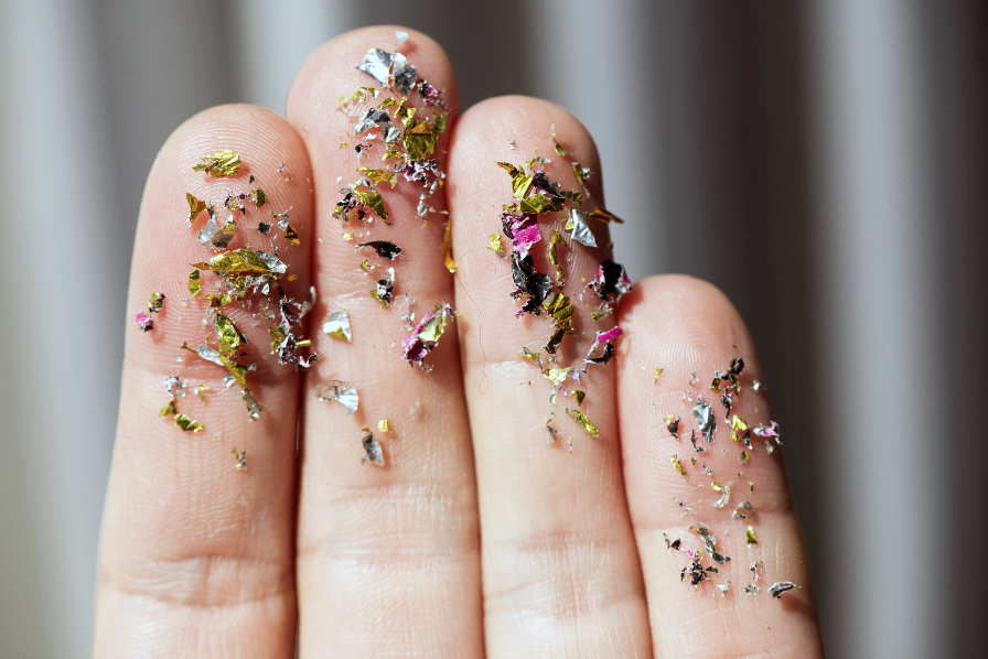 Colourful microplastics compared to human hand.